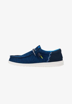 Scarpe slip-on blu navy con tomaia in tessuto testurizzato, suola in gomma bianca, cuciture decorative e lacci grigi con un dettaglio di colore accentato.