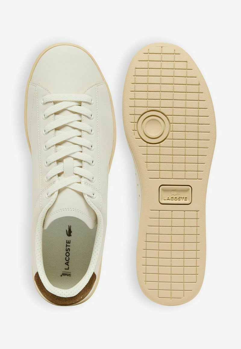 Sneaker bianco Lacoste con suola beige che mostra la vista dall'alto a sinistra e il motivo della suola a destra, incluso il logo del marchio e dettaglio marrone sul tallone.