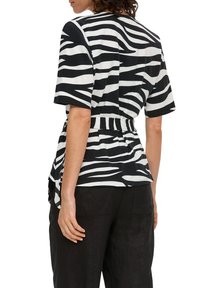 Zwart-wit gestreepte short-sleeve top met een aangesnoerde taille. Zachte stof met een relaxte pasvorm en een gebogen achterkant. 