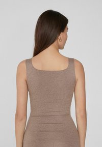 Débardeur marron moulant avec de larges bretelles et un décolleté carré, fabriqué à partir d'un matériau doux et texturé. Vue arrière montrée.