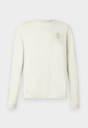 Långärmad tröja i krämfärgat bomullstyg med en diskret logotyp på vänster bröst, avslappnad passform och ribbade muddar.