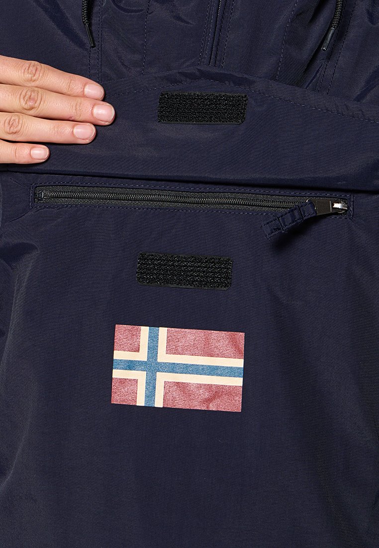 Intérieur d'une veste marine avec une poche zippée, un patch en Velcro et un design rectangulaire du drapeau norvégien comportant des couleurs rouge, bleu et blanc.