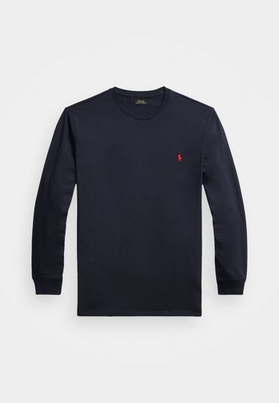 Marineblå langermet T-skjorte laget av bomull, med rund hals og en liten rød logo på brystet. Silkeaktig myk tekstur, avslappet passform.