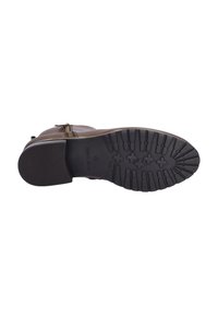 Braune Leder-Stiefelette mit seitlichem Reißverschluss, robuster Gummisohle mit strukturiertem Profil und minimalen dekorativen Hardware-Akzenten.