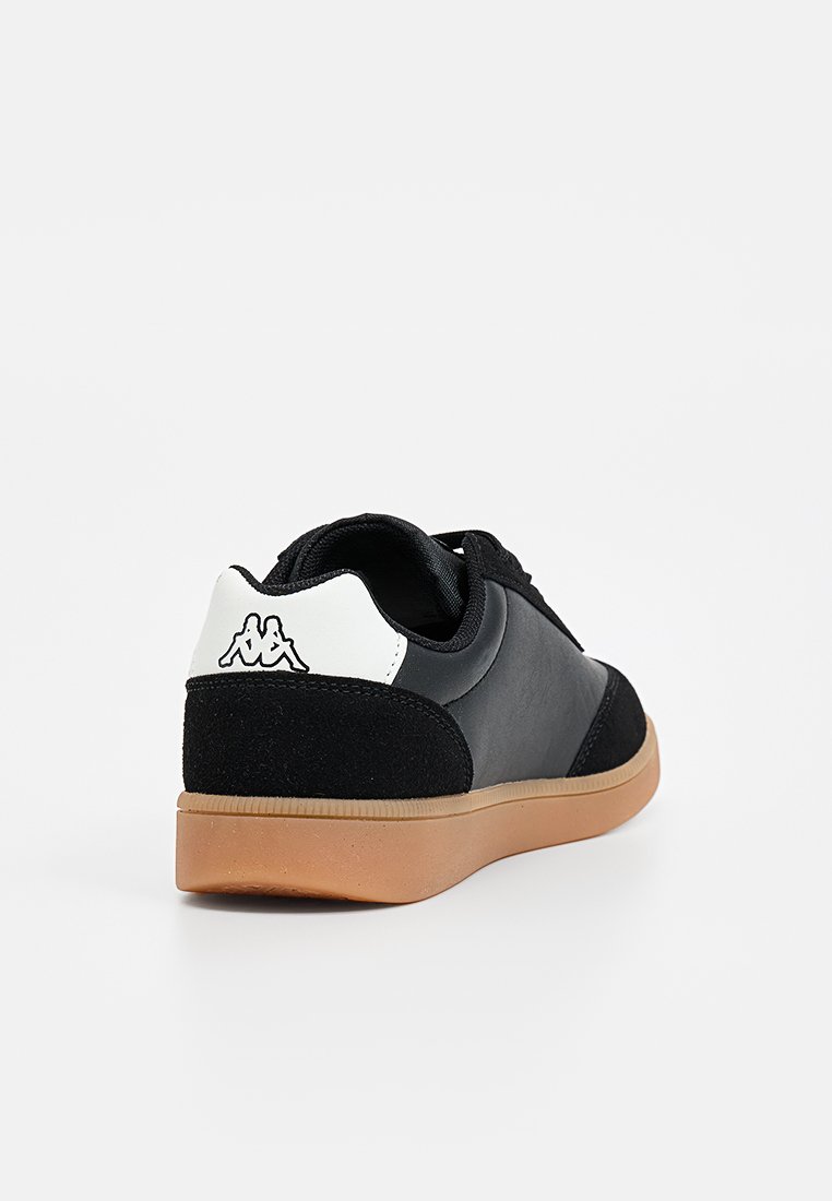 Baskets noires avec un mélange de matériaux lisses et texturés, comprenant une semelle en gomme et un accent de logo blanc sur le talon.