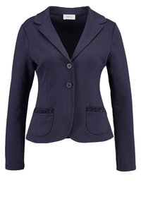 Tmavě modrý blejzr vyrobený z hladké tkaniny, s klopovým límcem, dvěma knoflíky a dvěma kapsami s texturovanými akcenty. Přizpůsobený střih.