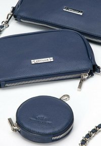 Clutch in pelle blu navy e portamonete circolare, con accessori in argento, chiusure con cerniera e marchio in rilievo sulle superfici. Inclusa una tracolla a catena.