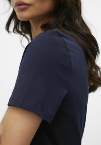 Marinblå t-shirt med kort ärm i mjuk bomull, med rund halsringning och snygg sömnad vid ärmar och fåll.