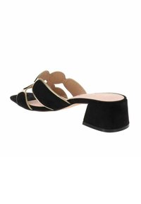 Mule nere in suede con design a ritaglio, punta affusolata e tacco basso e spesso, con una soletta liscia di colore chiaro.