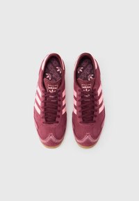 Burgundia punase seemisnahaga vabaajajalatsid roosade triipudega, ümara nina disain, sobiva sisetallaga, kummisest tallaga ja dekoratiivse õmblusega äärel.