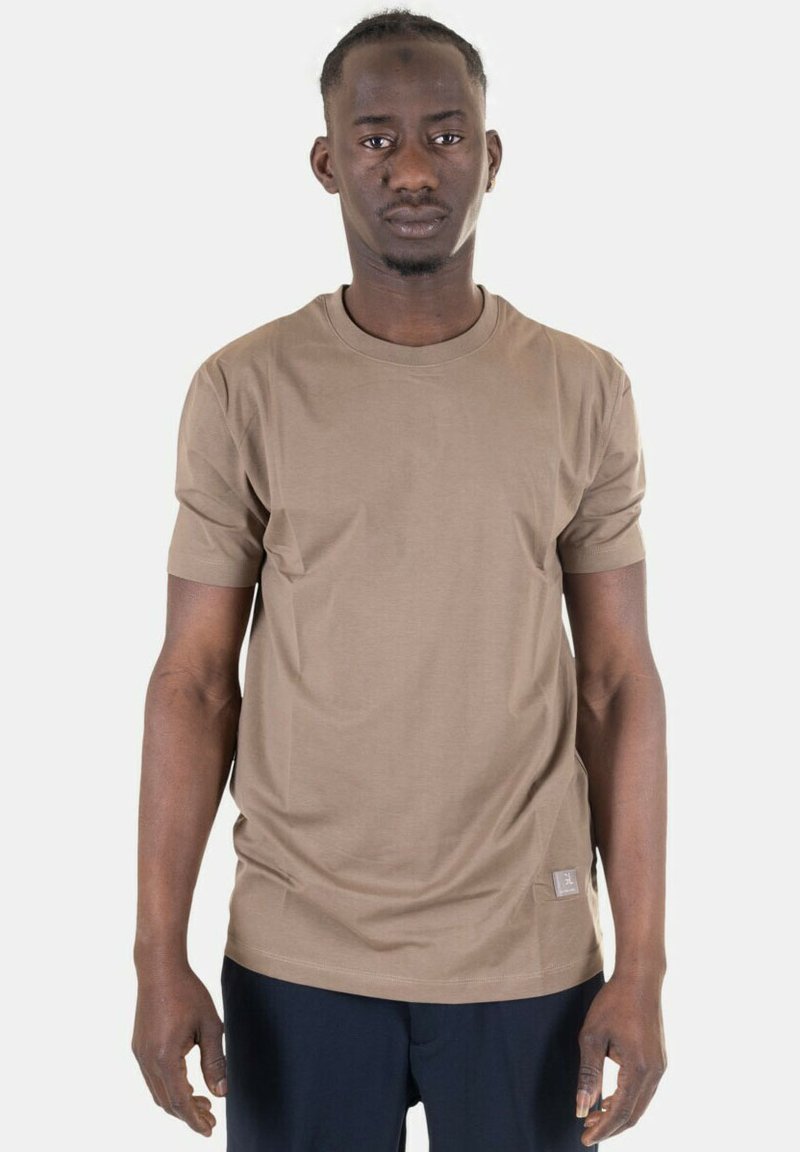 T-shirt a maniche corte, collo rotondo, in tessuto marrone chiaro con una trama liscia e una piccola etichetta con logo all'orlo inferiore.
