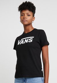 Musta puuvillapaita, jossa on pyöreä kaula-aukko, lyhyet hihat ja etupuolella valkoinen "VANS" -logo. Pehmeä tekstuuri, mukautuva malli ja rento tyyli.