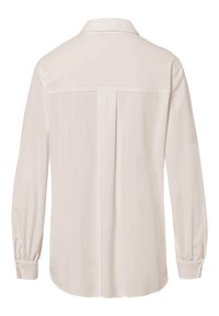 Lichtbeige blouse met lange mouwen en een kraag, voorzien van een rugbies, plooi detail en knoopmanchetten, gemaakt van een gladde, zachte stof.