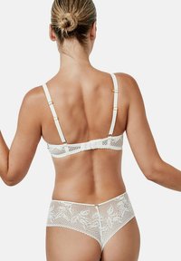 Wit kanten lingerie set met bloemenpatronen op de rug, verstelbare banden en een haak-en-oogsluiting op de beha.