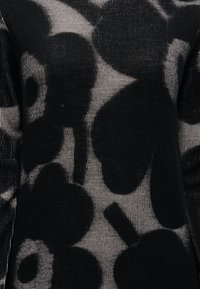 Μαύρο πλεκτό πουλόβερ με μεγάλο ανθικό μοτίβο σε γκρι, ριμπ υφή, εφαρμοστή γραμμή και μακριά μανίκια.