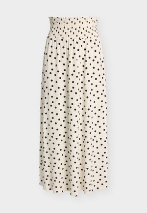 Jupe midi couleur crème à pois noirs avec une ceinture élastique froncée, présentée sur un fond uni.