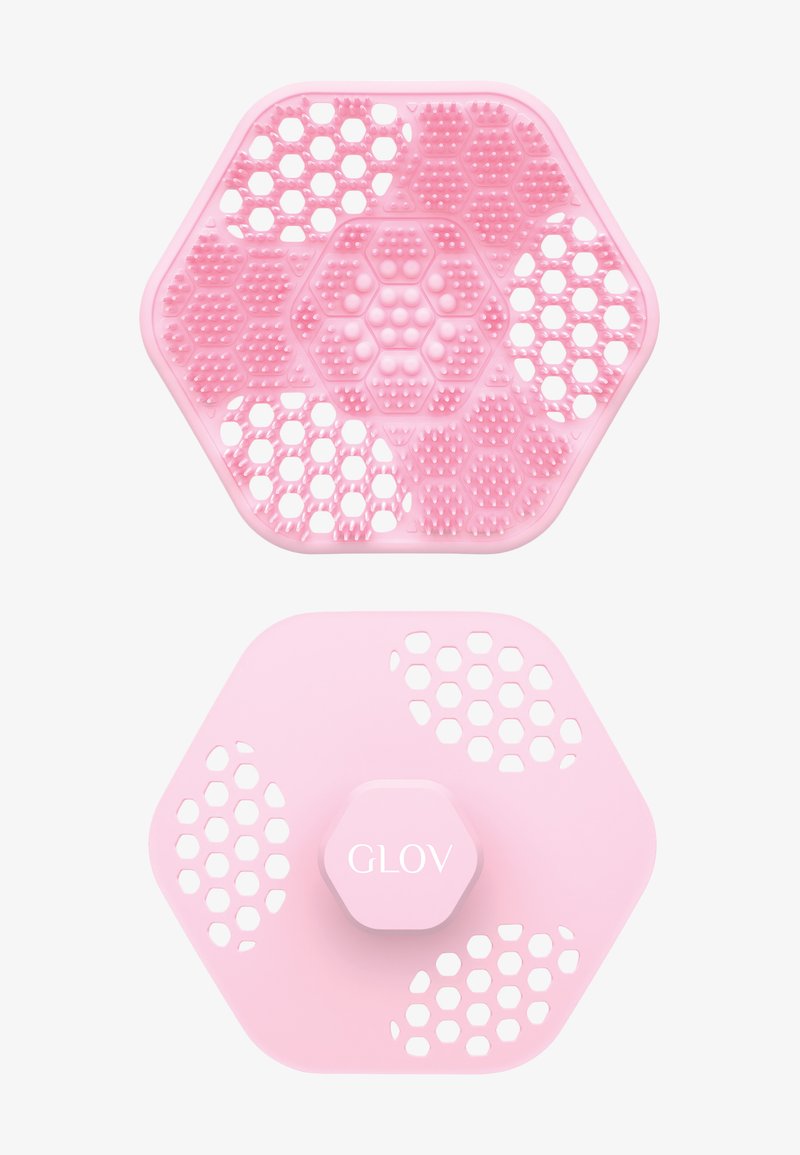 Różowa silikonowa podkładka do czyszczenia w kształcie sześciokąta z teksturą w sześciokąty i kropki, z centralnym akcentem oznaczonym napisem "GLOV."