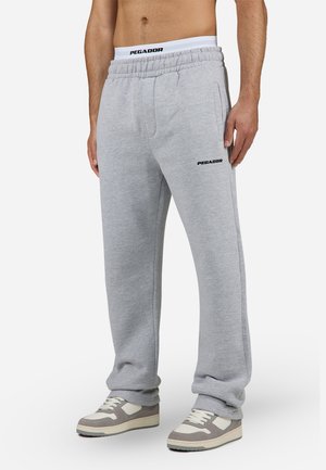 Grå bomulls joggebukser med elastisk midje, sidelommer og "PEGADOR" logo i svart på venstre lår.