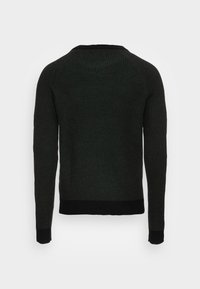 Mörkgrön stickad tröja med ribbat mönster, långa ärmar och svarta detaljer vid ärmsluten och nederkant. Klassisk rund halsringning.