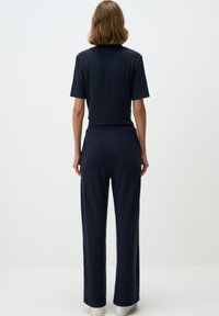 Navy loungewear set met een kortarmige top en brede pijpen. Gemaakt van zachte stof met een relaxte pasvorm en een elastische tailleband.