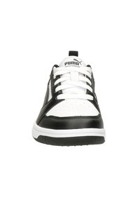 Schwarz-weiße Sportschuhe mit einem glatten Lederobermaterial, durchge perforiertem Zehenbereich, weißen Schnürsenkeln und einer schwarzen Gummisohle. PUMA-Logo auf der Zunge.