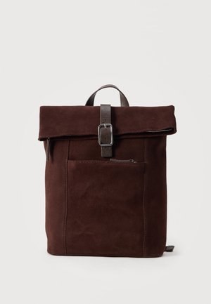 Mørkebrun ruskindsrygsæk med foldet top, sikret med en læderrem og metalklap, frontlomme med lynlås og bærehåndtag.