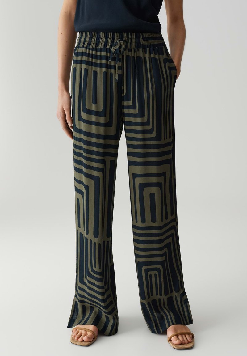 Lässige, gemusterte Hosen in Dunkelgrün und Marineblau mit geometrischen Linien. Mit einem elastischen Bund und seitlichen Taschen. Glattes Material.