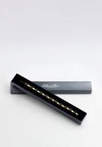 Bracciale in oro con elementi a forma di cuore collegati, esposto in una scatola nera con il logo 'Sofia Milani Jewels' sul coperchio.
