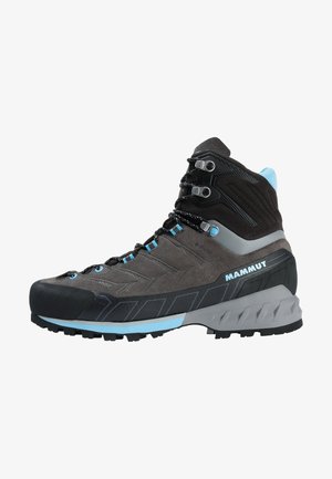 Bota de senderismo alta en gris y negro con detalles en azul, ojales de metal, suela texturizada y la marca "MAMMUT" en el lateral.