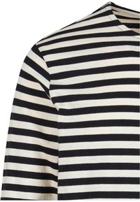 Chemise rayée avec des bandes horizontales noires et crème, col rond et manches courtes, fabriquée en tissu en coton doux.