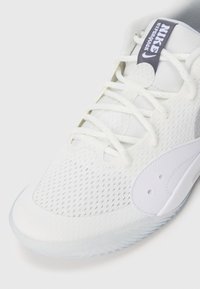 Białe sneakersy Nike Hyperquick z siateczkowym wierzchem, teksturowaną powierzchnią i przezroczystą podeszwą. Posiadają sznurowadła i ciemnoszary metka z logo.