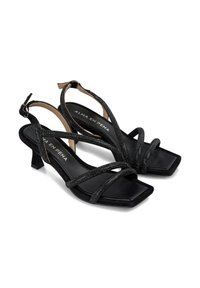 Sandalias negras de tiras con punta cuadrada y tacón bajo en bloque. Con tiras brillantes y un forro interior suave con el nombre de la marca.