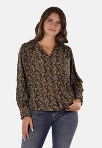 Blusa a maniche lunghe in tessuto nero con motivo paisley in oro, marrone e crema. Presenta una chiusura con bottoni sulla parte frontale e un colletto arricciato.
