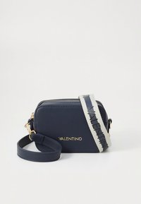 Navy plava Valentino torbica na rame sa zlatnim logotipom, dvostrukim patentnim zatvaračem i podesivim bijelim remenom s crnim Valentino tekstom.