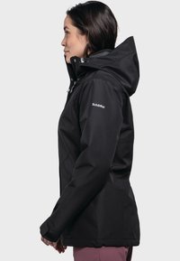 Giacca impermeabile nera con cappuccio, caratterizzata da una superficie liscia, cordini regolabili e un logo sulla manica sinistra.