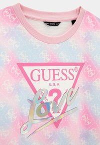 Sweatshirt con sfumatura rosa e blu caratterizzato da un motivo a diamanti, un logo triangolare con "GUESS U.S.A." e un dettaglio di testo iridescente "Love".