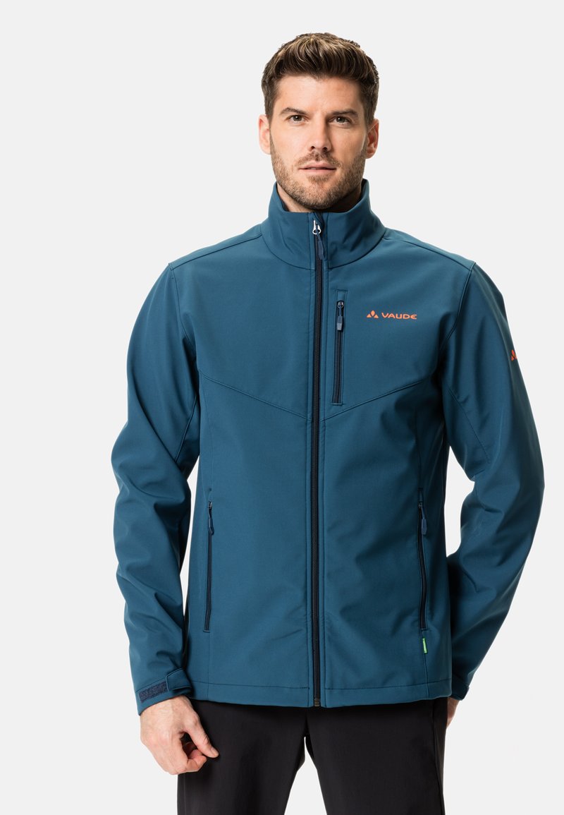 Veste softshell teal avec col montant, fermeture éclair à l'avant et deux poches latérales. Présente le logo Vaude et des accents en Velcro sur les poignets.