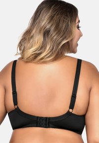 Soutien-gorge noir avec bretelles réglables, surface en tissu lisse et fermeture à crochets au dos. Dispose de bords festonnés le long des bretelles.