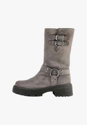 Bota de ante gris hasta la rodilla con dos hebillas plateadas en la parte superior, una correa decorativa y un detalle de anillo, y una suela de goma texturizada negra.