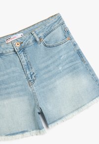 Pantalones cortos de denim azul claro con dobladillo deshilachado, diseño de cinco bolsillos y cierre de botón. Presenta detalles de desgaste y decoloración notables. Tamaño 42.