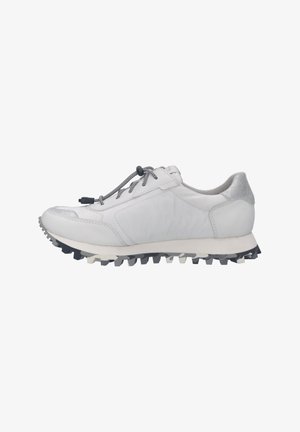 Zapatilla deportiva blanca con suela gris, suela exterior texturizada, lengüeta trasera plateada y cordones elásticos negros y blancos con cierre de tope.