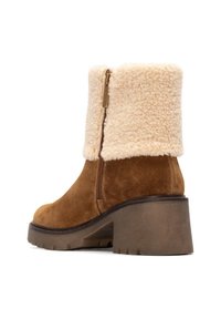 Stivaletti in suede marrone con un bordo in pelliccia sintetica beige chiaro, cerniera laterale e suola in gomma resistente, dotati di tacco a blocco.