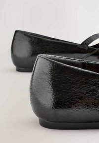 Mustad musta ballerina stiilis kingad, millel on läikiv, tekstuuriga sünteetiline pind, ümmargune varvas ja madal konts. Omavad sujuvat sisevoodrit ja lofti disaini.