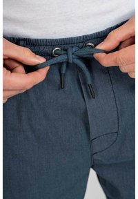 Pantalones cortos con cordón en tejido azul oscuro, con una cinturilla elástica, ojales de metal y cordones tejidos texturizados.