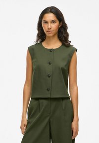 Ärmelloses, olivgrünes Cropped-Top mit rundem Ausschnitt und fünf schwarzen Knöpfen auf der Vorderseite, aus strukturiertem Stoff.