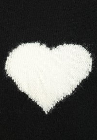 Weißes, gestricktes Herz auf einem schwarzen, gestrickten Stoffhintergrund, der Textur und Stichdetails zeigt.