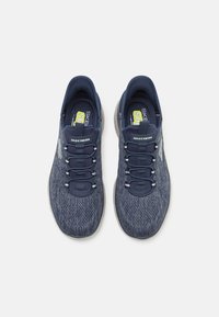 Blue mesh athletic shoes with elastic laces, cushioned insole, and contrasting gray outsole. Features "SKECHERS" logo on side.