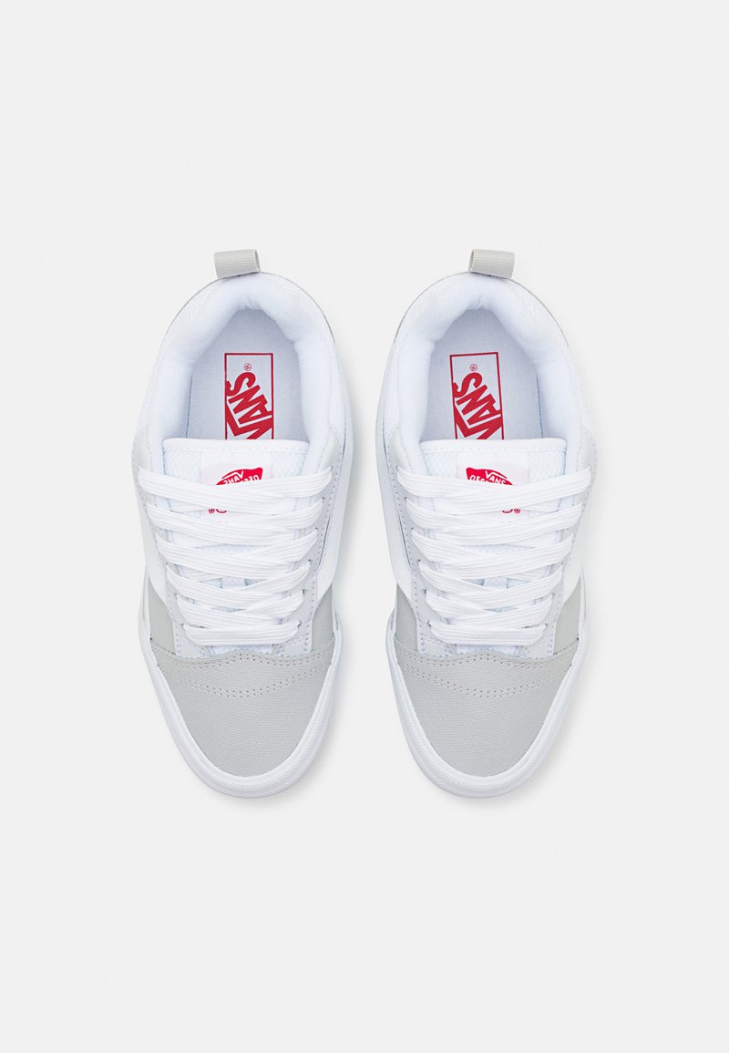 Zapatillas Vans en una combinación de colores gris y blanco, con un collar acolchado, cordones blancos y un logo rojo en la lengüeta.