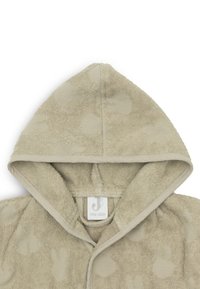 Beige capuchonhanddoek met konijnenpatronen, gemaakt van getextureerd badstof. Voorzien van een genaaid label en een eenvoudig, functioneel ontwerp. Één maat.