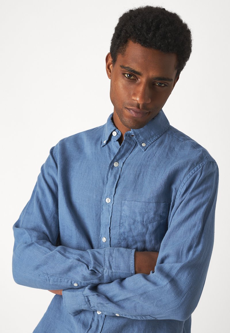 Helles Leinen-Hemd mit Knopfleiste, langen Ärmeln, Brusttasche und weißen Knöpfen. Strukturierter Stoff mit lockerer Passform und Kragen.